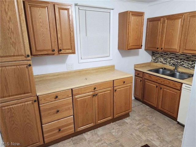 kitchen featuring white dishwasher, sink, and backsplash