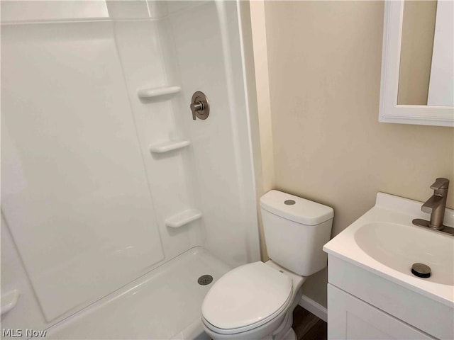 bathroom featuring vanity, toilet, and a shower