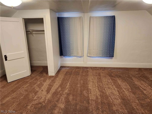 unfurnished bedroom with vaulted ceiling, carpet, and a closet