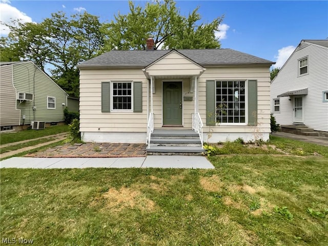 bungalow-style home featuring central AC and a front lawn