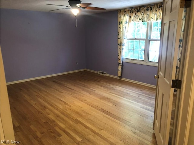 unfurnished room featuring hardwood / wood-style floors, ceiling fan, and a healthy amount of sunlight