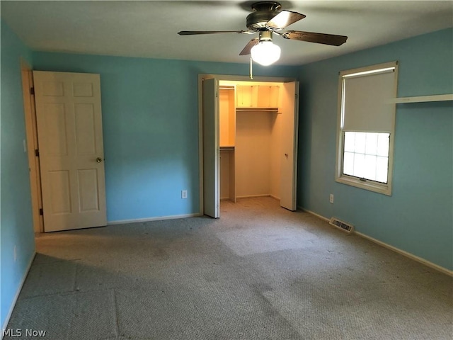 unfurnished bedroom featuring ceiling fan, a walk in closet, light carpet, and a closet