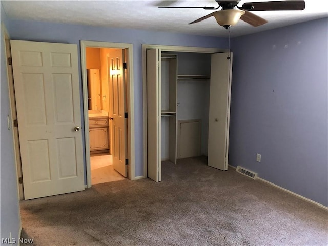 unfurnished bedroom with carpet flooring, a closet, ensuite bath, and ceiling fan