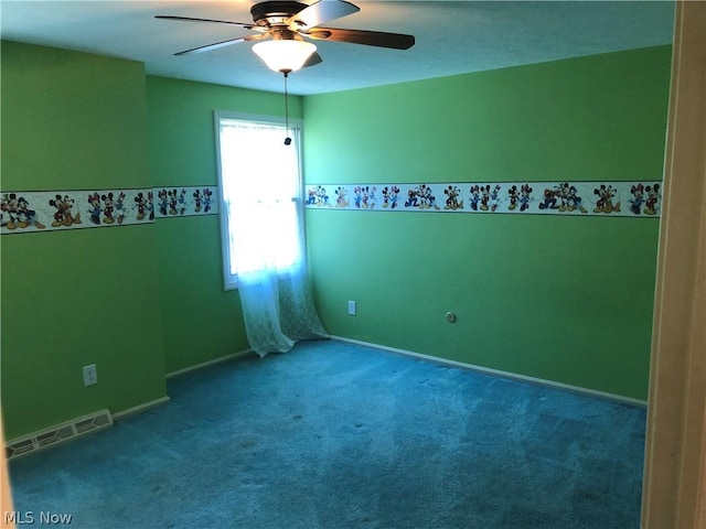 carpeted spare room with ceiling fan