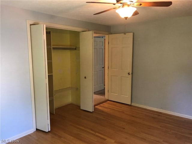 unfurnished bedroom featuring ceiling fan, a closet, and wood-type flooring