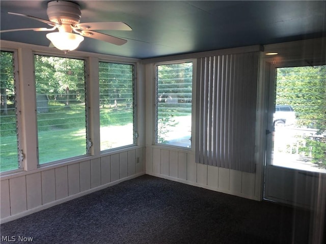 unfurnished sunroom featuring ceiling fan