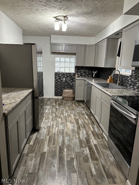 kitchen featuring sink, gray cabinets, stainless steel appliances, and dark hardwood / wood-style floors