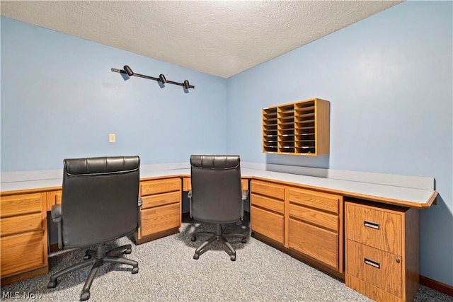 home office featuring light colored carpet and a textured ceiling