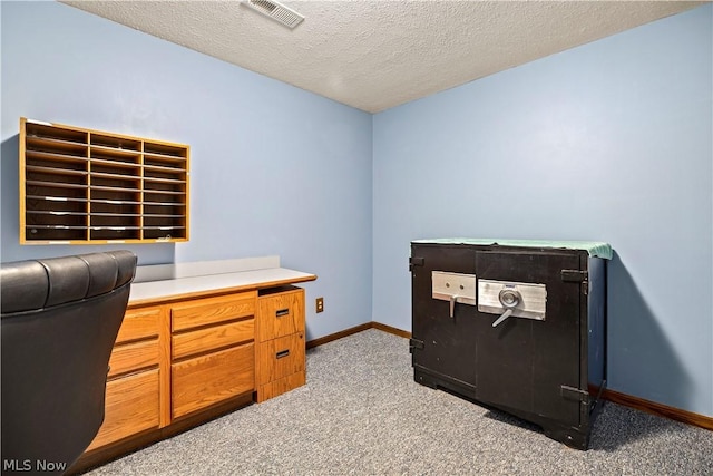 carpeted office featuring a textured ceiling