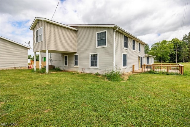 rear view of property featuring a yard and a deck