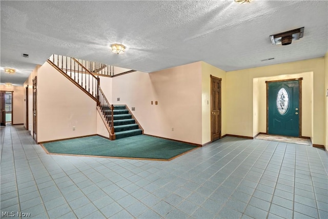 foyer entrance with a textured ceiling and tile patterned floors