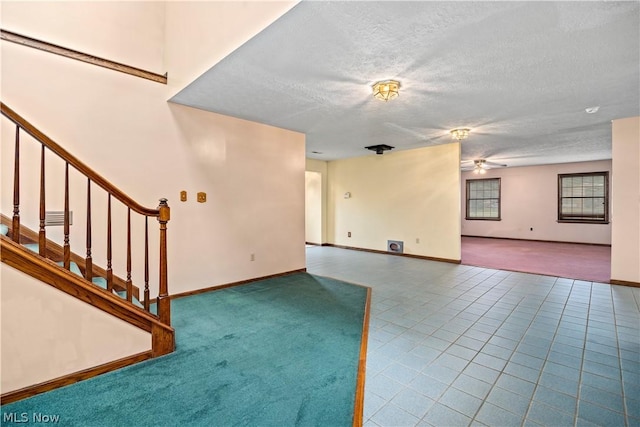 unfurnished living room featuring tile patterned flooring, a textured ceiling, and ceiling fan