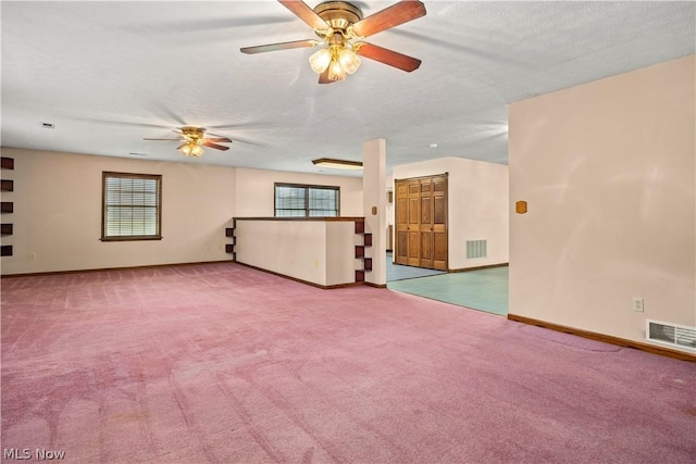 carpeted spare room with ceiling fan and a textured ceiling