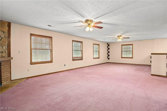 unfurnished living room featuring a fireplace, light carpet, a textured ceiling, and ceiling fan