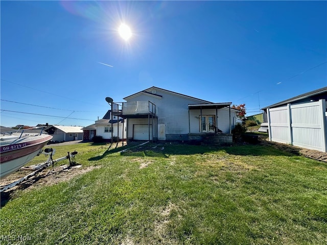 back of property with a lawn and a balcony