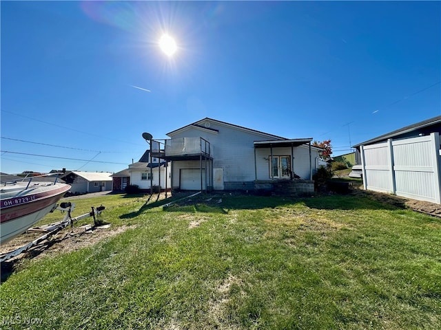 back of property with a yard and a balcony