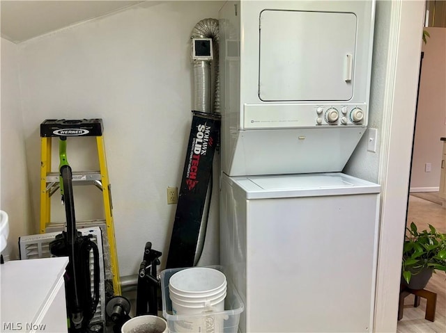 clothes washing area featuring stacked washer / dryer