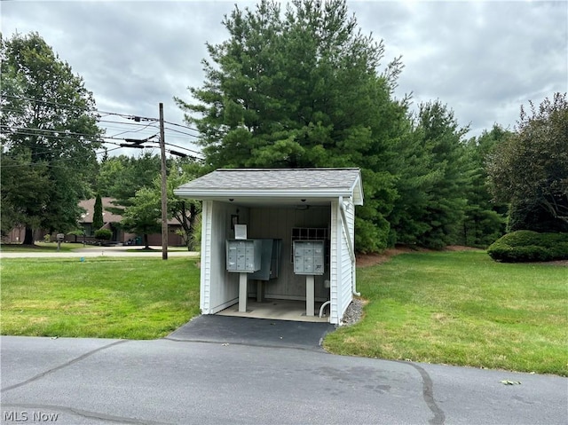 view of property's community with mail boxes and a lawn