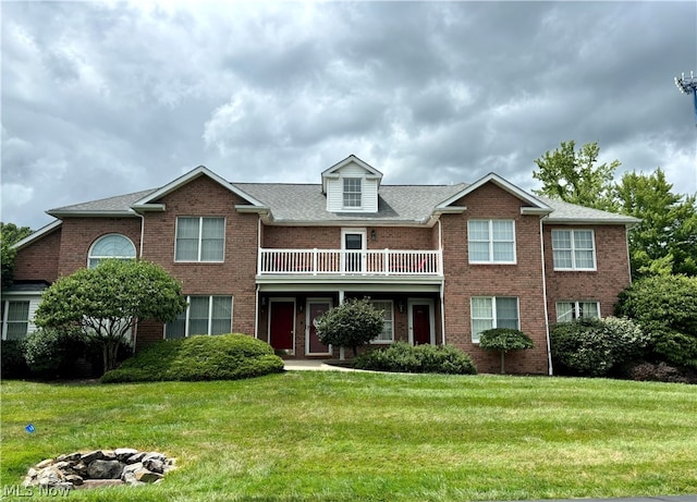 view of front of home with a balcony and a front yard