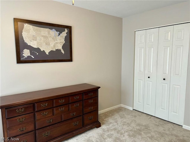 bedroom featuring light colored carpet and a closet