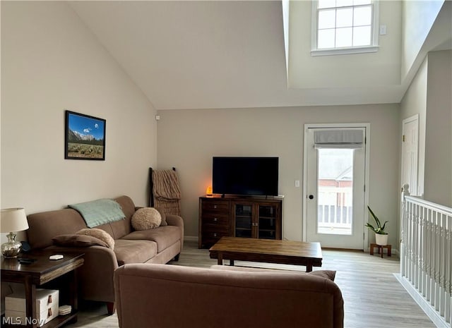 living room featuring high vaulted ceiling and light hardwood / wood-style floors