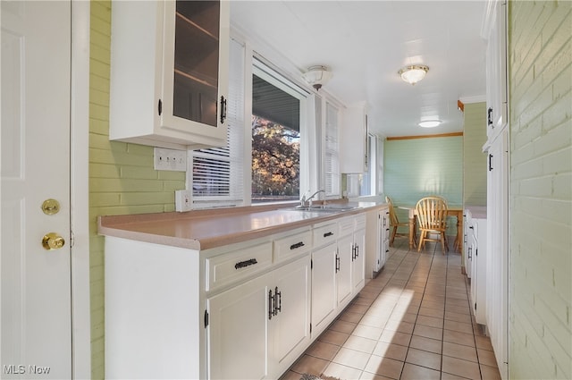 kitchen with white cabinetry, light tile patterned floors, and sink