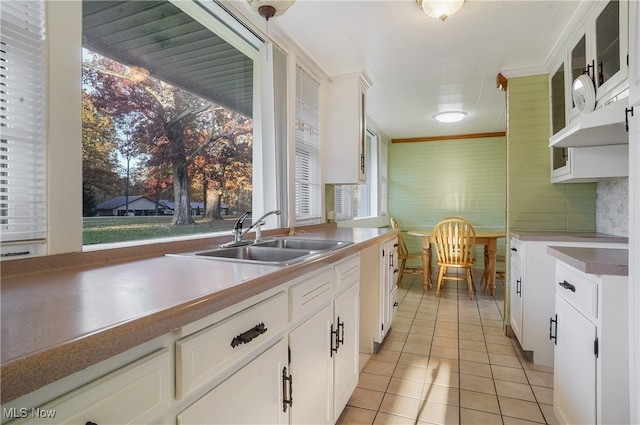 kitchen featuring sink, white cabinetry, hanging light fixtures, and light tile patterned flooring