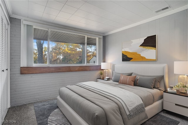 bedroom featuring crown molding and dark carpet