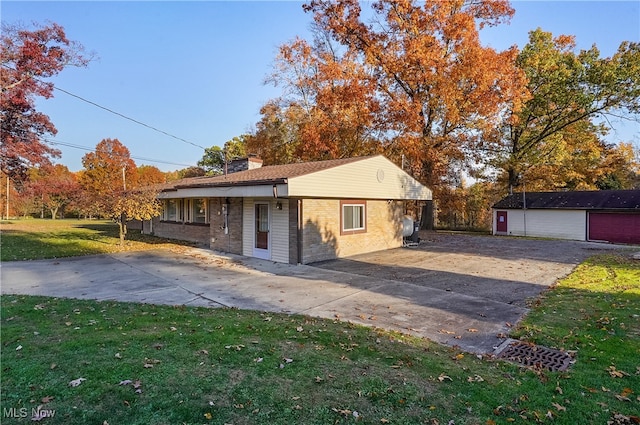 view of front of home featuring a front lawn, an outbuilding, and a garage