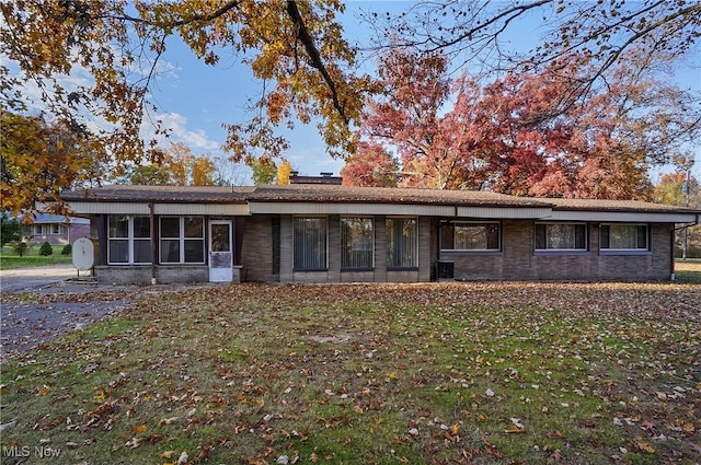 single story home with a front lawn and a sunroom