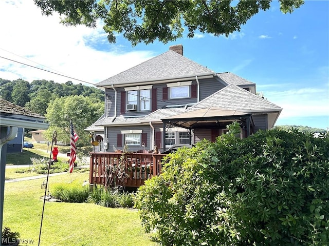 view of front of property featuring a gazebo, a chimney, roof with shingles, and a front yard