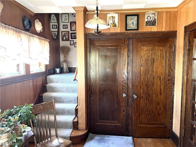 entrance foyer with stairs and wooden walls