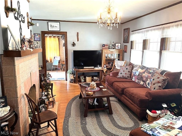 living room with crown molding, a fireplace, radiator, an inviting chandelier, and wood finished floors