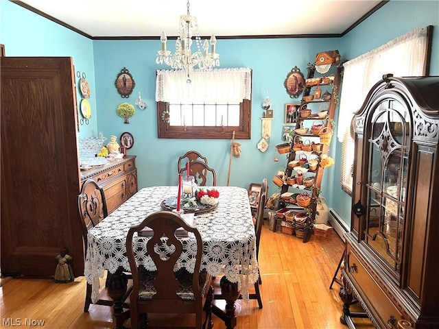 dining room featuring an inviting chandelier, ornamental molding, and hardwood / wood-style floors