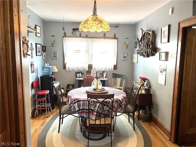 dining room with light wood-style flooring and baseboards