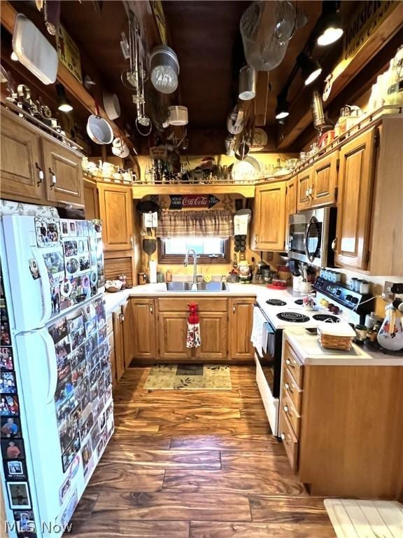 kitchen featuring light countertops, stainless steel microwave, freestanding refrigerator, a sink, and range with electric cooktop