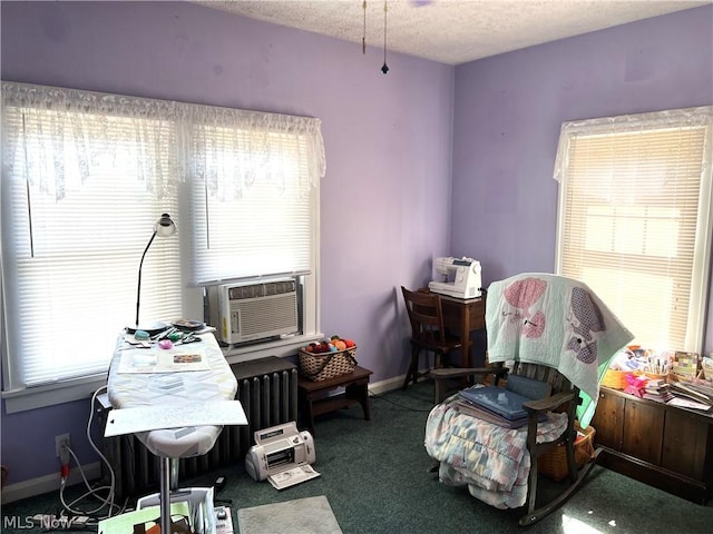 interior space featuring a textured ceiling, carpet flooring, cooling unit, and baseboards