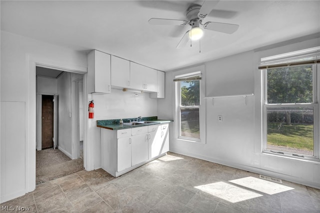 kitchen featuring a wealth of natural light, sink, white cabinets, and ceiling fan