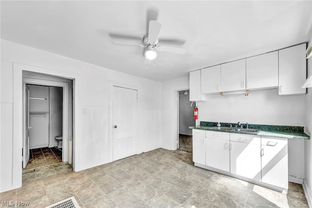 kitchen with ceiling fan, white cabinetry, and sink