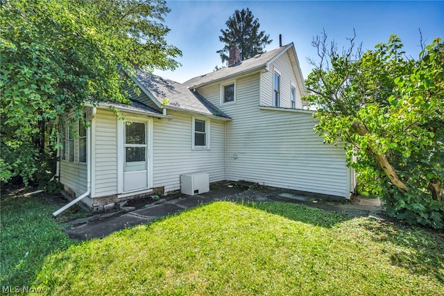 rear view of house featuring a lawn