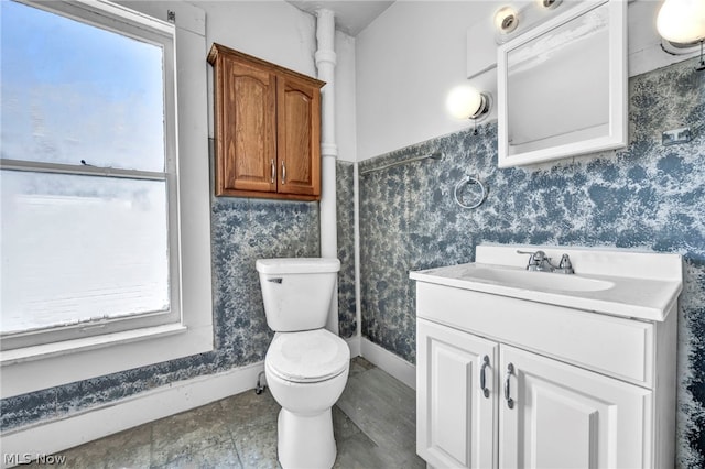 bathroom featuring vanity, a healthy amount of sunlight, and toilet