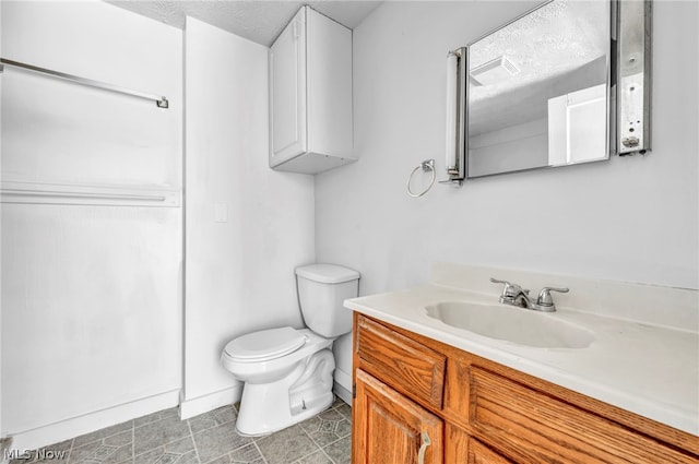 bathroom with vanity, a textured ceiling, and toilet