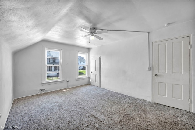 additional living space featuring carpet, ceiling fan, a textured ceiling, and vaulted ceiling