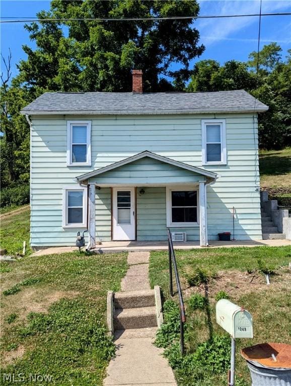 view of front of house with covered porch and a front yard