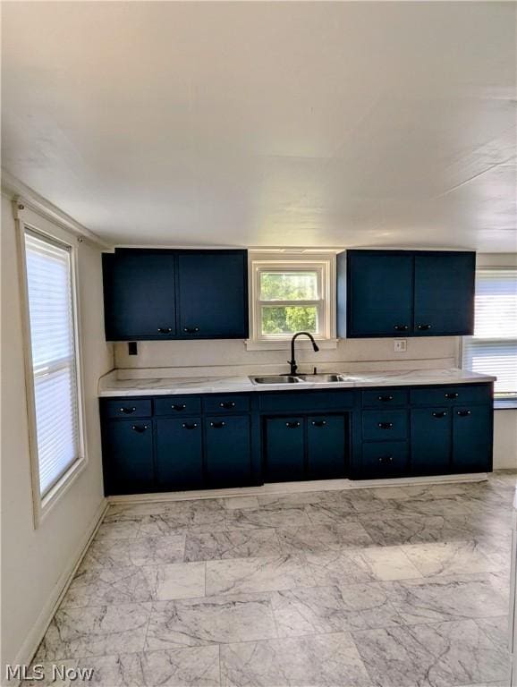 kitchen with blue cabinetry, a healthy amount of sunlight, and sink