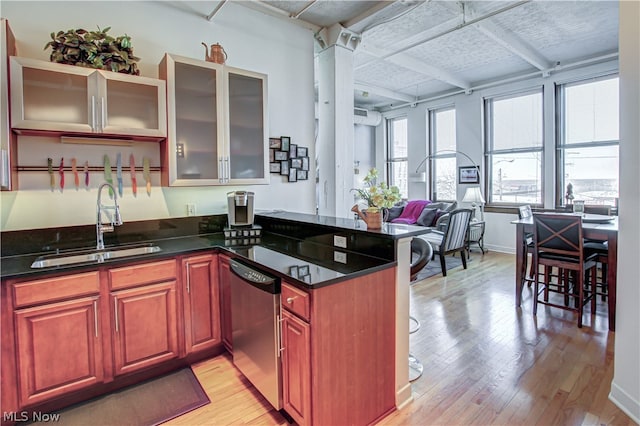 kitchen featuring sink, dishwasher, kitchen peninsula, and light hardwood / wood-style floors