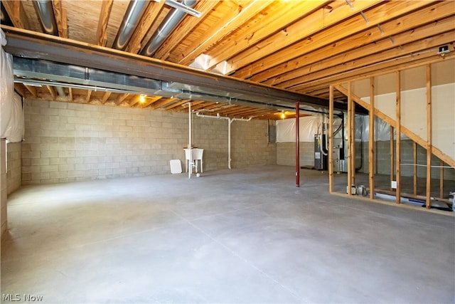 unfinished basement featuring water heater, a sink, electric panel, and heating unit