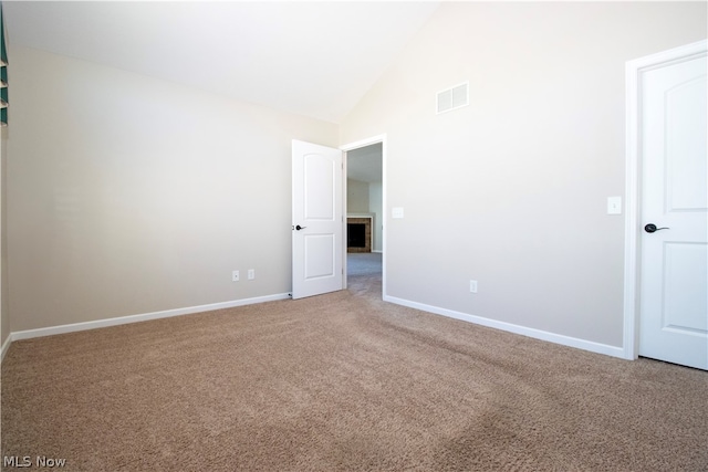 carpeted empty room featuring high vaulted ceiling