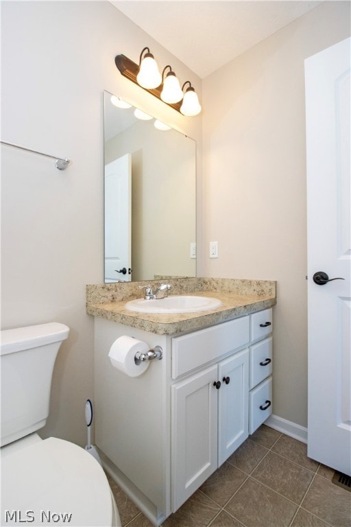 bathroom with vanity, toilet, and tile patterned floors