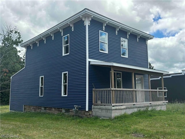 exterior space with covered porch and a lawn